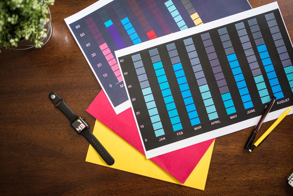 Flat lay poslovnih grafikona s pametnim satom, olovkama i dokumentima na stolu